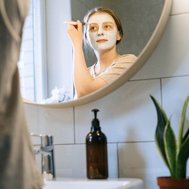 woman applying facial treatment